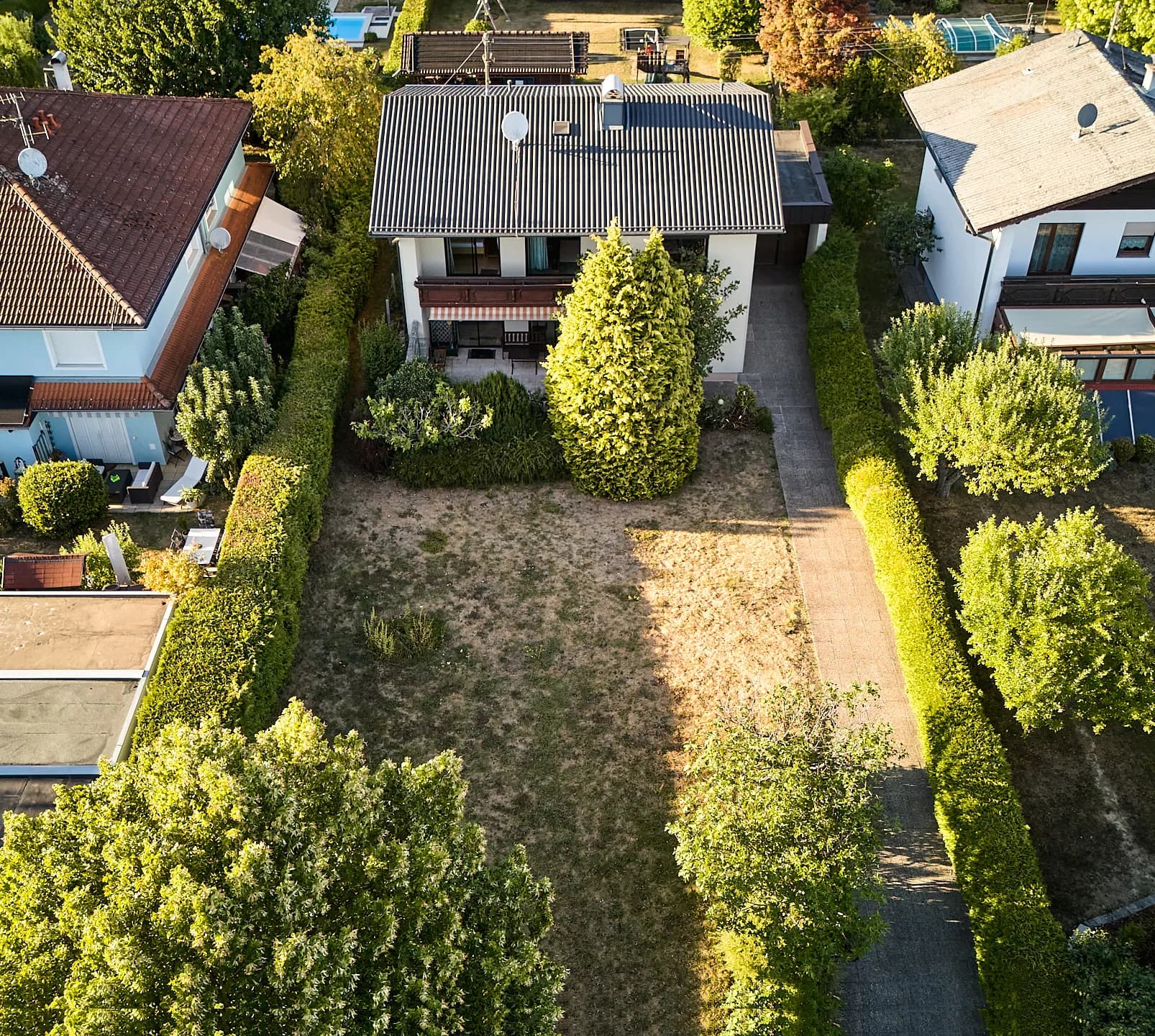Das Haus am hinteren Ende des Grundstücks, davor der Garten in voller Breite